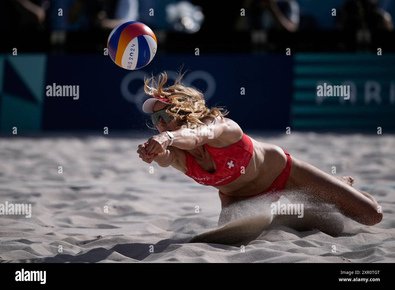 Switzerland's Nina Brunner dives for the ball during the women's semi-final beach volleyball match between Switzerland and Canada at Eiffel Tower Stadium at the 2024 Summer Olympics, Thursday, Aug. 8, 2024, in Paris, France. (AP Photo/Louise Delmotte) Stockfoto