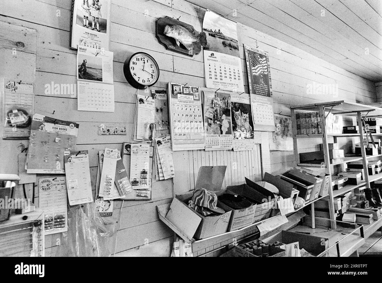Mazedonien, Arkansas, USA – 23. Juni 2024: Horizontale Aufnahme einer Wand voller Kalender und Waren in einem alten Arkansas Country Store 1975. Stockfoto