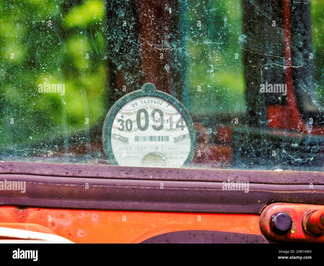 Nahaufnahme der abgelaufenen Steuer-Scheibe eines Oldtimers hinter einer staubigen Windschutzscheibe. Stockfoto