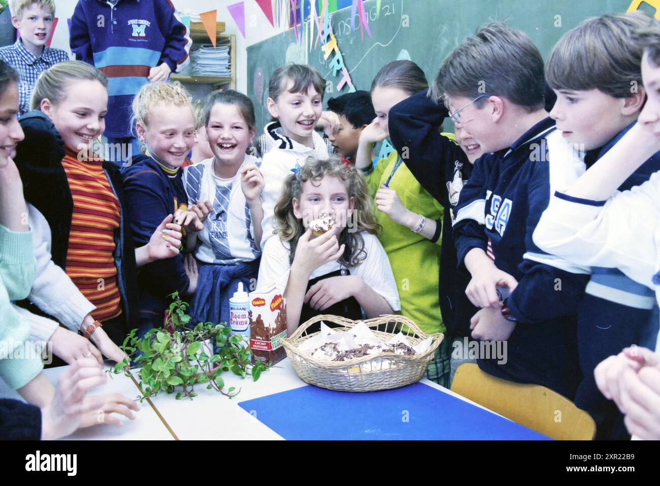 Gruppe von Kindern um einen Geburtstagskameraden Whizgle Dutch News: Historische Bilder für die Zukunft. Erkunden Sie die Vergangenheit der Niederlande mit modernen Perspektiven durch Bilder von niederländischen Agenturen. Verbinden der Ereignisse von gestern mit den Erkenntnissen von morgen. Begeben Sie sich auf eine zeitlose Reise mit Geschichten, die unsere Zukunft prägen. Stockfoto