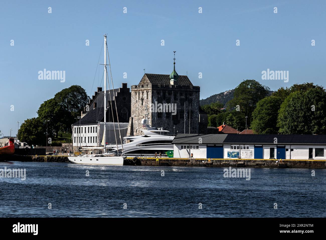 Segelboot Champagne Hippy am Bradbenken Kai im Hafen von Bergen, Norwegen. Der alte Rosenkrantz-Turm, Bergenhus und Haakonshallen im Hintergrund Stockfoto