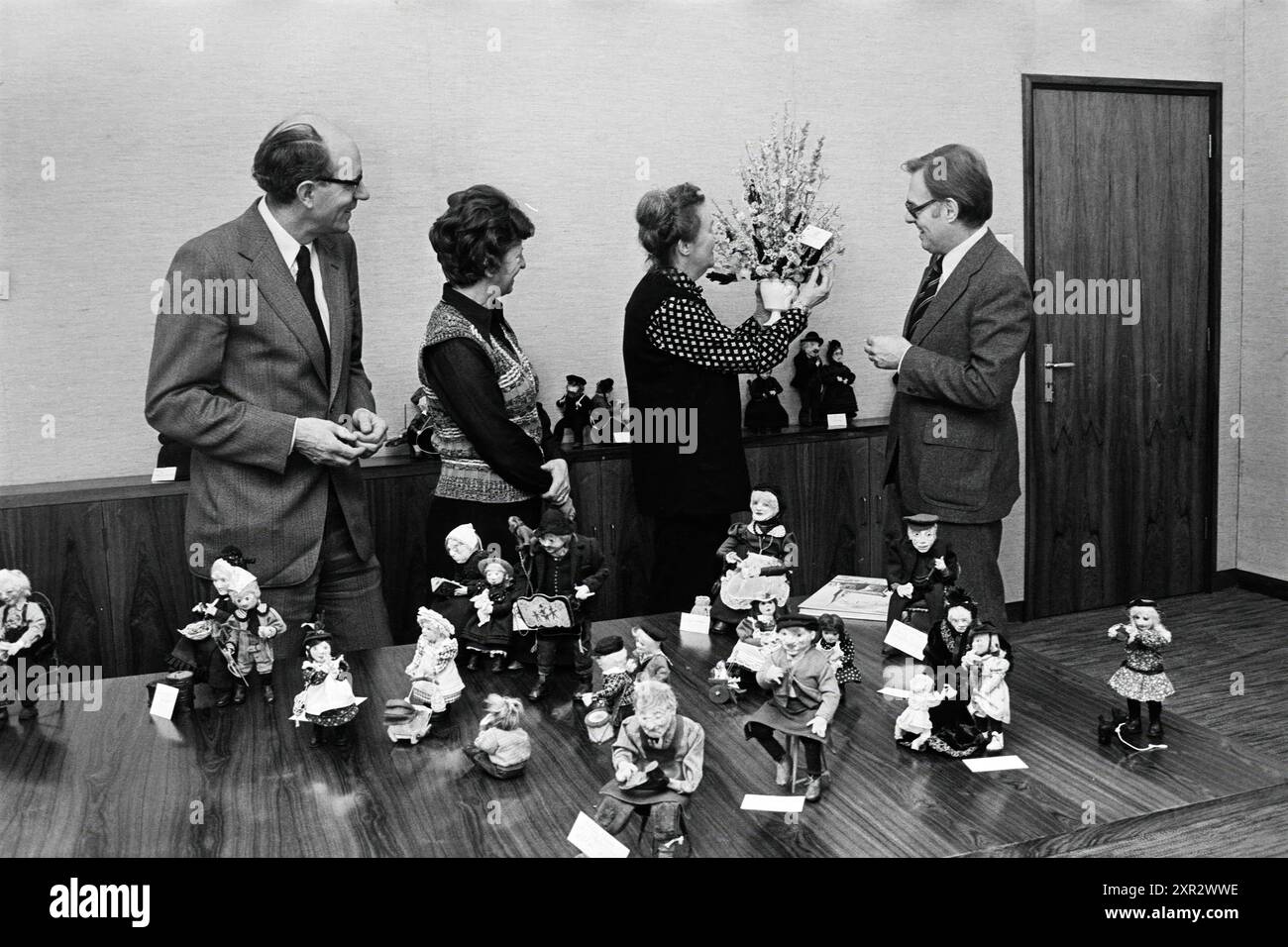 Zwei Männer und zwei Frauen schauen sich einen Tisch mit Marionetten an, Whizgle Dutch News: Historical Images Tailored for the Future. Erkunden Sie die Vergangenheit der Niederlande mit modernen Perspektiven durch Bilder von niederländischen Agenturen. Verbinden der Ereignisse von gestern mit den Erkenntnissen von morgen. Begeben Sie sich auf eine zeitlose Reise mit Geschichten, die unsere Zukunft prägen. Stockfoto