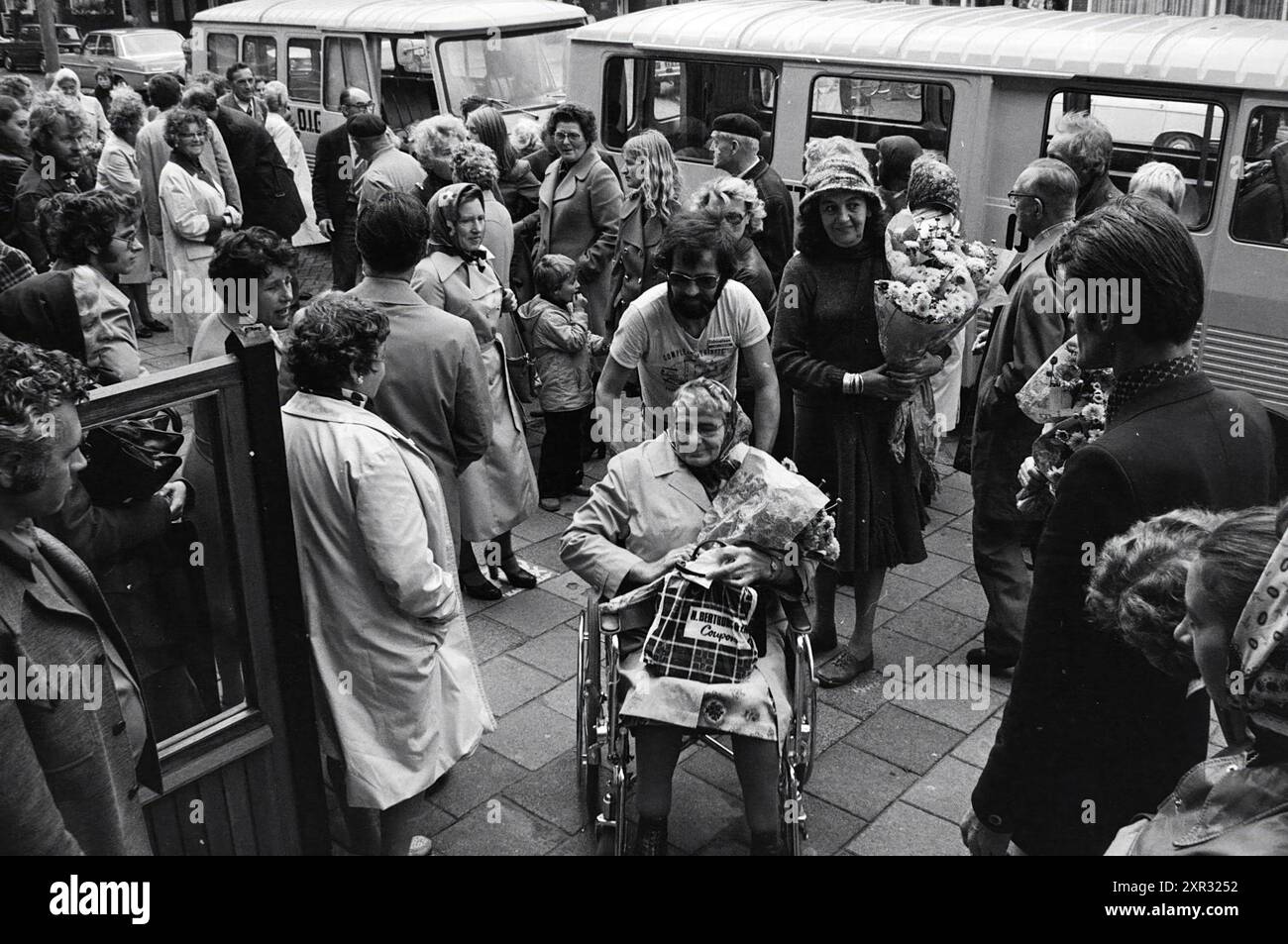 Ältere Menschen warten vor dem Hotel Royal auf den Transport von der O.I.G. Foundation., Whizgle Dutch News: Historische Bilder für die Zukunft. Erkunden Sie die Vergangenheit der Niederlande mit modernen Perspektiven durch Bilder von niederländischen Agenturen. Verbinden der Ereignisse von gestern mit den Erkenntnissen von morgen. Begeben Sie sich auf eine zeitlose Reise mit Geschichten, die unsere Zukunft prägen. Stockfoto