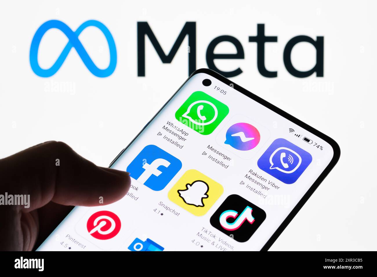 Nahaufnahme eines Smartphone-Bildschirms mit verschiedenen Social Media- und Kommunikations-Apps mit Meta-Logo im Hintergrund, das die Vielfalt der Apps zeigt Stockfoto