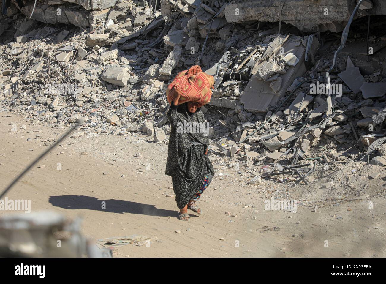 Gaza. August 2024. Eine Frau flüchtet am 8. August 2024 aus den östlichen Bezirken der Stadt Khan Younis im südlichen Gazastreifen. Nach einer neuen Evakuierungsanordnung der israelischen Behörden sagten UN-humanitäre Helfer am Donnerstag, dass ihre Partner Tausende von Gazern erneut aus Teilen des Gebiets Khan Younis im Westen in Richtung Al Mawasi flohen. Quelle: Rizek Abdeljawad/Xinhua/Alamy Live News Stockfoto