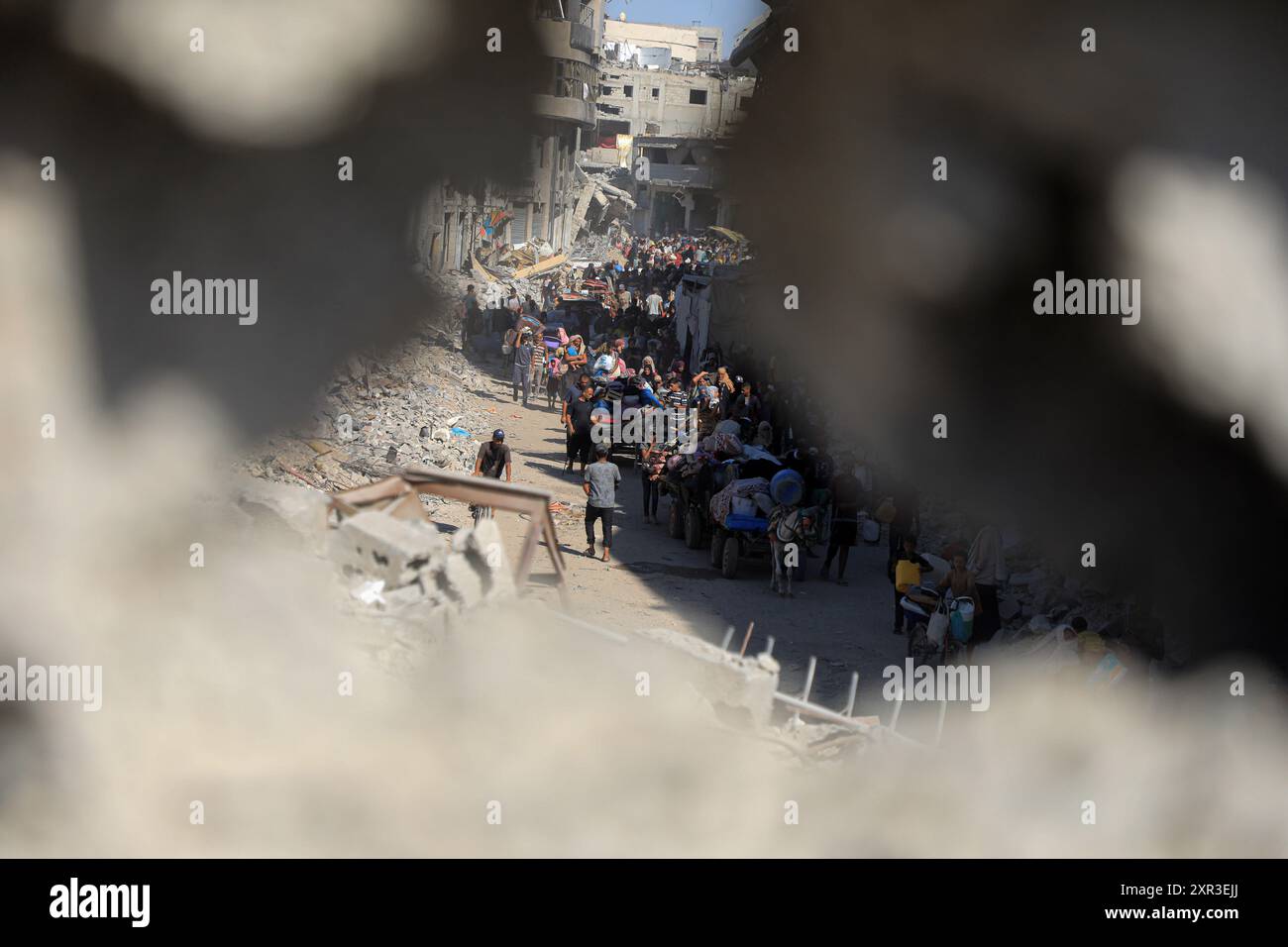 Gaza. August 2024. Am 8. August 2024 fliehen Menschen aus den östlichen Bezirken der Stadt Khan Younis im südlichen Gazastreifen. Nach einer neuen Evakuierungsanordnung der israelischen Behörden sagten UN-humanitäre Helfer am Donnerstag, dass ihre Partner Tausende von Gazern erneut aus Teilen des Gebiets Khan Younis im Westen in Richtung Al Mawasi flohen. Quelle: Rizek Abdeljawad/Xinhua/Alamy Live News Stockfoto