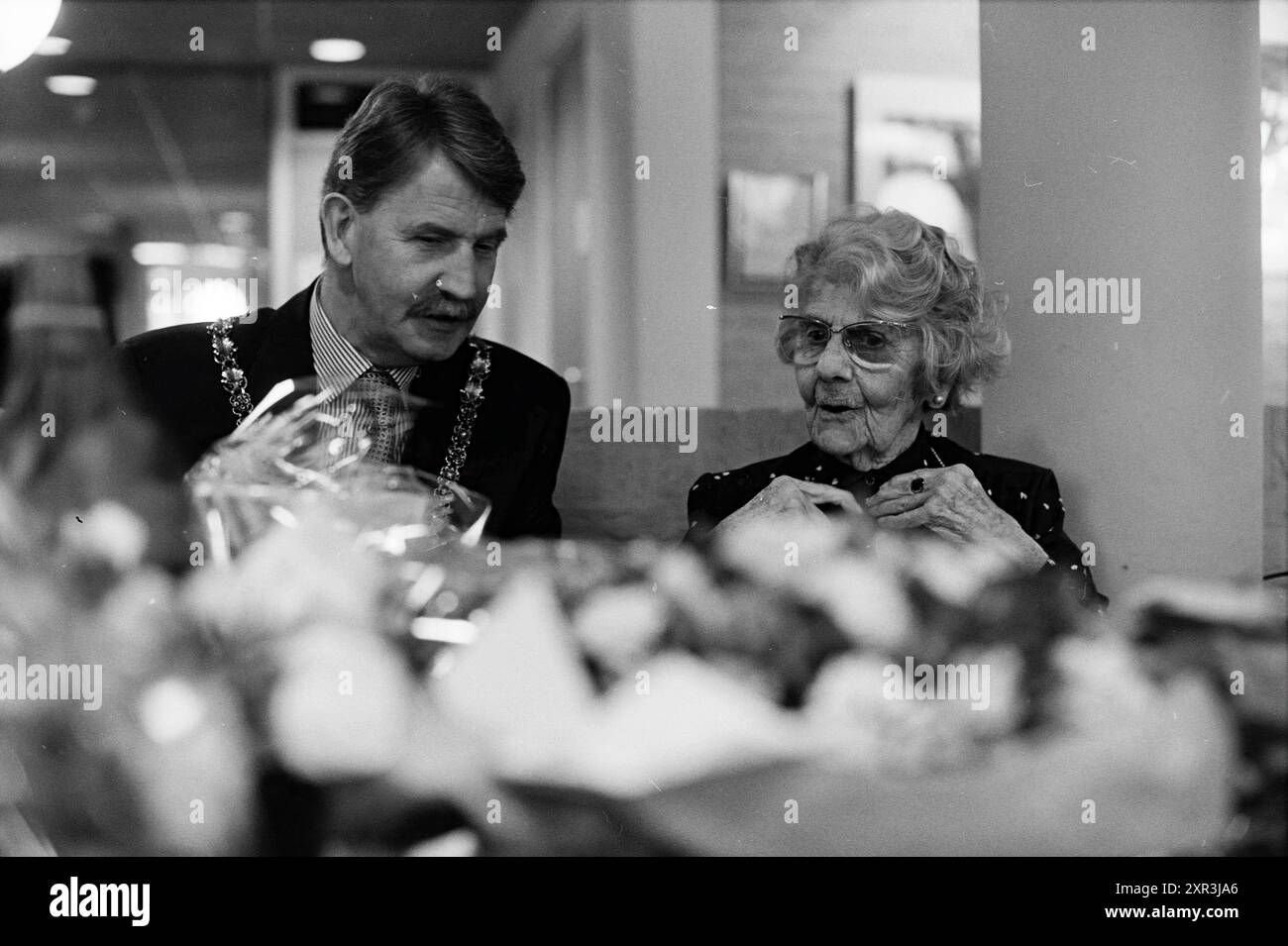 Frau Hoogland, 100 Jahre alt, erhält einen Besuch von Bürgermeister Kamphuis, Bloemendaal, Whizgle Dutch News: Historische Bilder zugeschnitten auf die Zukunft. Erkunden Sie die Vergangenheit der Niederlande mit modernen Perspektiven durch Bilder von niederländischen Agenturen. Verbinden der Ereignisse von gestern mit den Erkenntnissen von morgen. Begeben Sie sich auf eine zeitlose Reise mit Geschichten, die unsere Zukunft prägen. Stockfoto