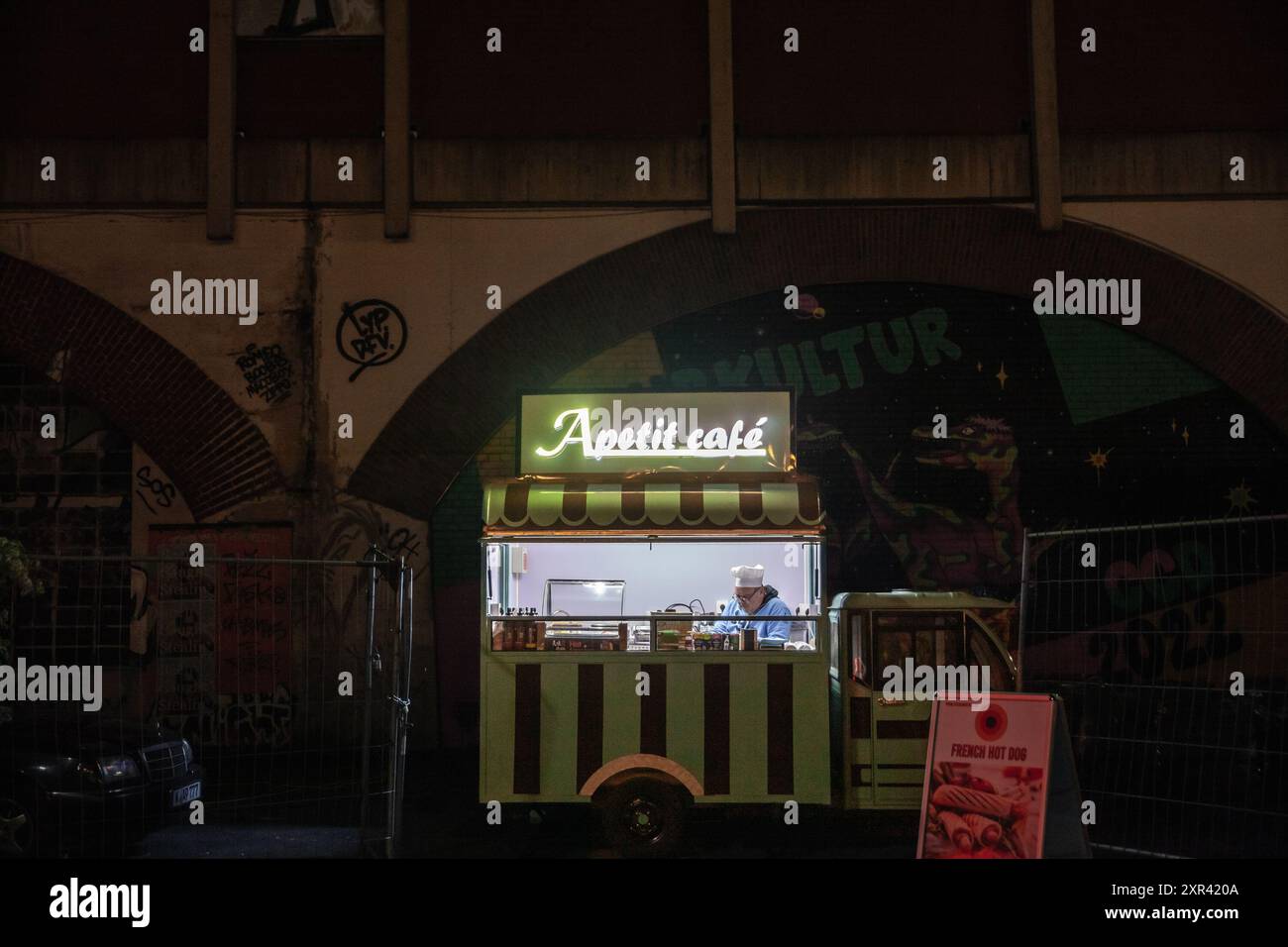 Ein lebendiger Food Truck in Köln, Deutschland, bei Nacht gefangen. Der kleine Truck serviert Kaffee und verschiedene Snacks, was zur Dynamik der Stadt beiträgt Stockfoto