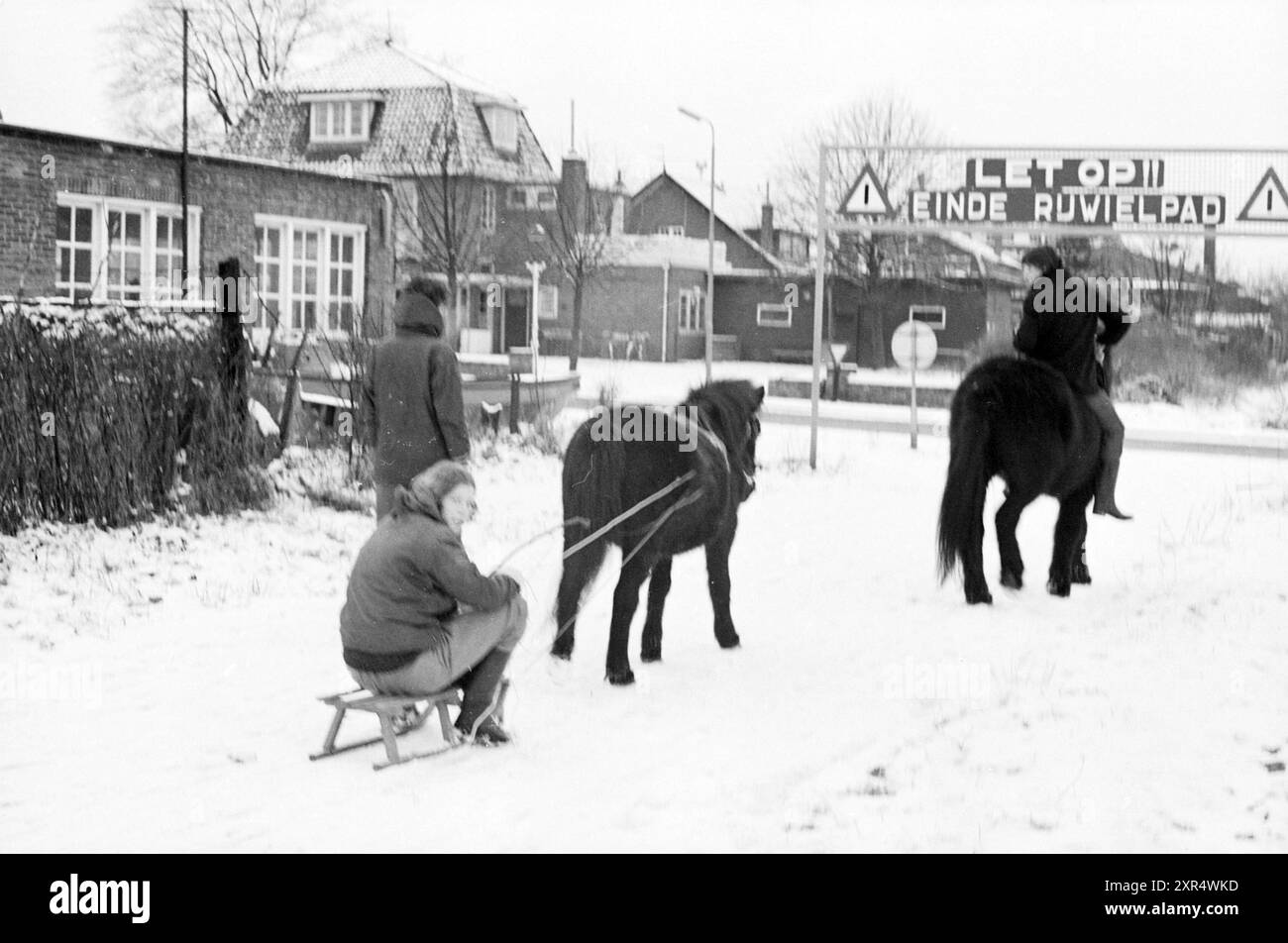 Reiten und Rodeln auf einem Fahrradweg im Schnee, um 1966, Whizgle Dutch News: Historische Bilder zugeschnitten auf die Zukunft. Erkunden Sie die Vergangenheit der Niederlande mit modernen Perspektiven durch Bilder von niederländischen Agenturen. Verbinden der Ereignisse von gestern mit den Erkenntnissen von morgen. Begeben Sie sich auf eine zeitlose Reise mit Geschichten, die unsere Zukunft prägen. Stockfoto