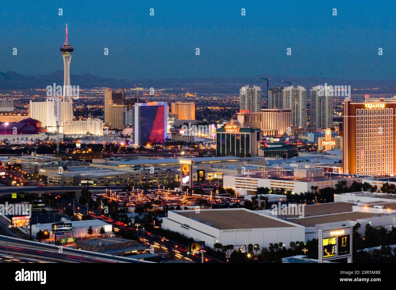 Die Abenddämmerung beginnt in der Wüste von Las Vegas und die Lichter leuchten auf die Kasinohotels entlang des Strip, darunter Stratosphere, Stardust, Frontier und T Stockfoto Die Abenddämmerung beginnt in der Wüste von Las Vegas und die Lichter leuchten auf die Kasinohotels entlang des Strip, darunter Stratosphere, Stardust, Frontier und T Stockfoto
