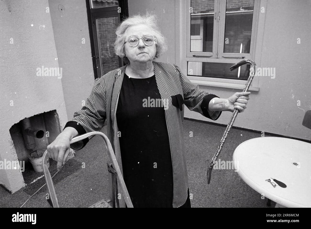 Frau Wiedijk besetzte im Haus Harmenjansweg, mit Brechstange in der Hand, Haarlem, Harmenjansweg, Niederlande, 24-04-1989, Whizgle Dutch News: historische Bilder für die Zukunft. Erkunden Sie die Vergangenheit der Niederlande mit modernen Perspektiven durch Bilder von niederländischen Agenturen. Verbinden der Ereignisse von gestern mit den Erkenntnissen von morgen. Begeben Sie sich auf eine zeitlose Reise mit Geschichten, die unsere Zukunft prägen. Stockfoto