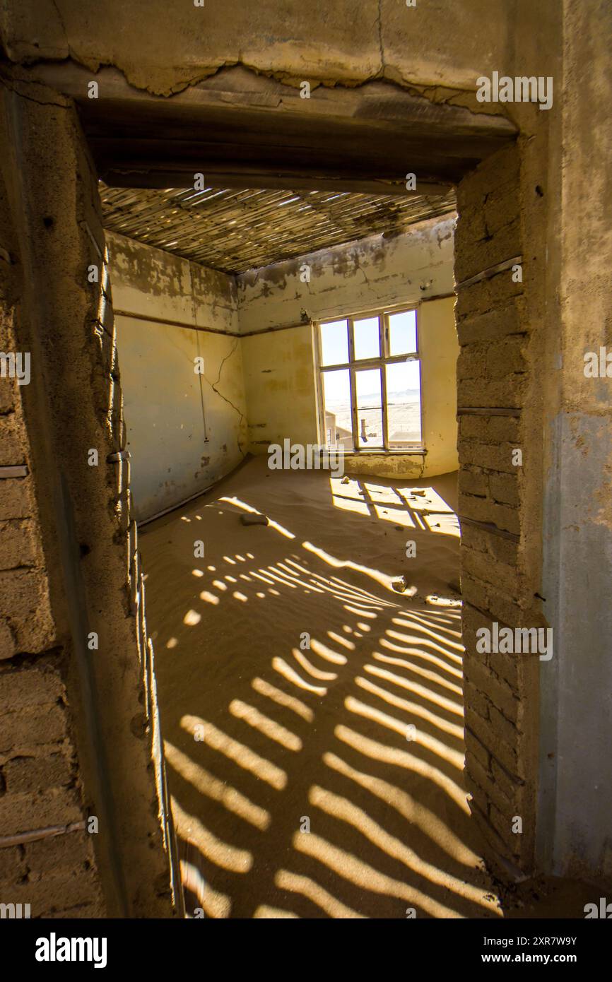 Licht und Schatten von einem kaputten Dach in einem sandgefüllten Raum in Kolmanskop Stockfoto