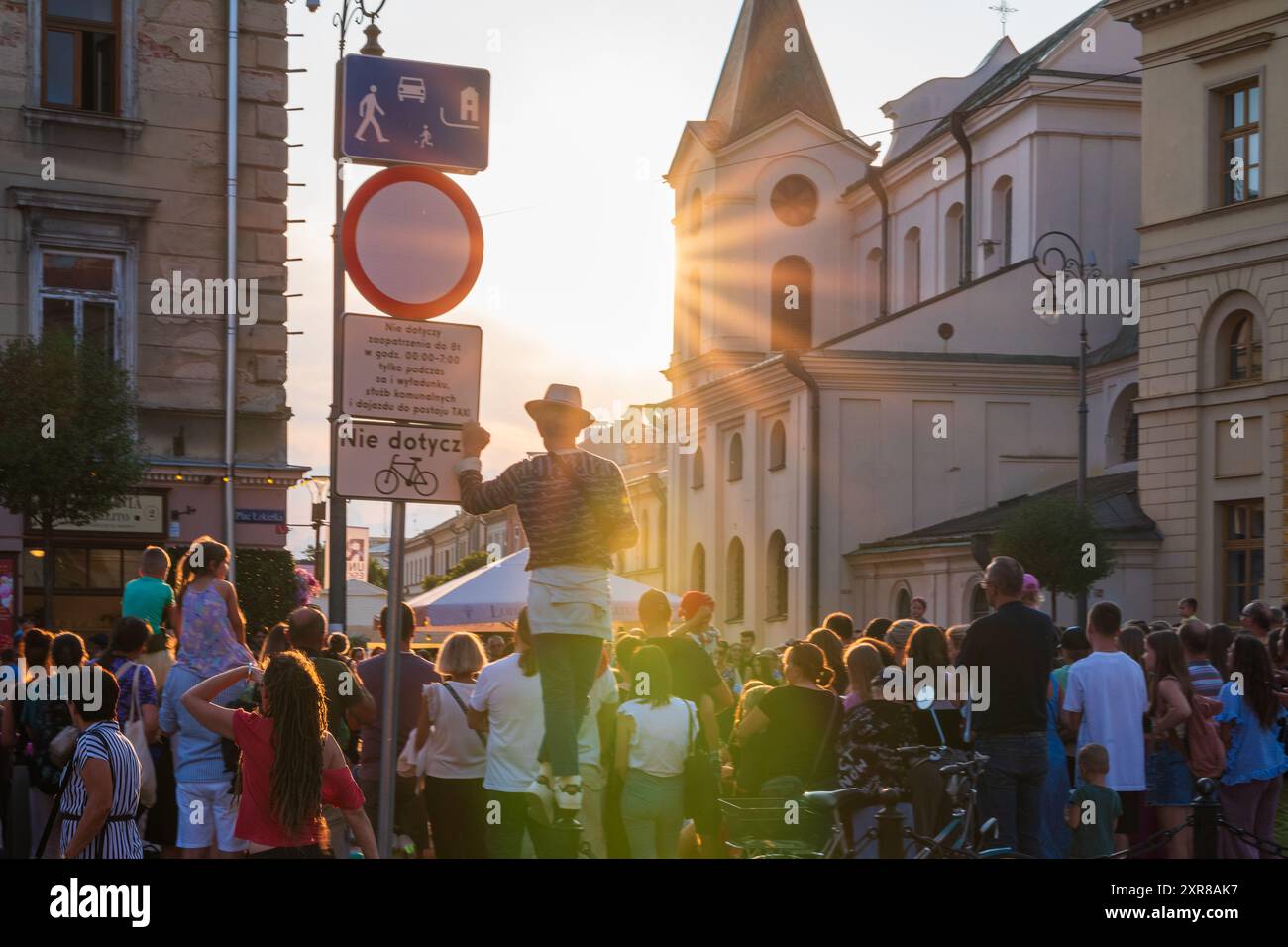 Lublin, Polen 26. Juli 2024 Mann mit einem Hut, der hoch über anderen Zuschauern steht, um einen Straßenkünstler beim Zirkus-Straßenfest zu sehen Stockfoto
