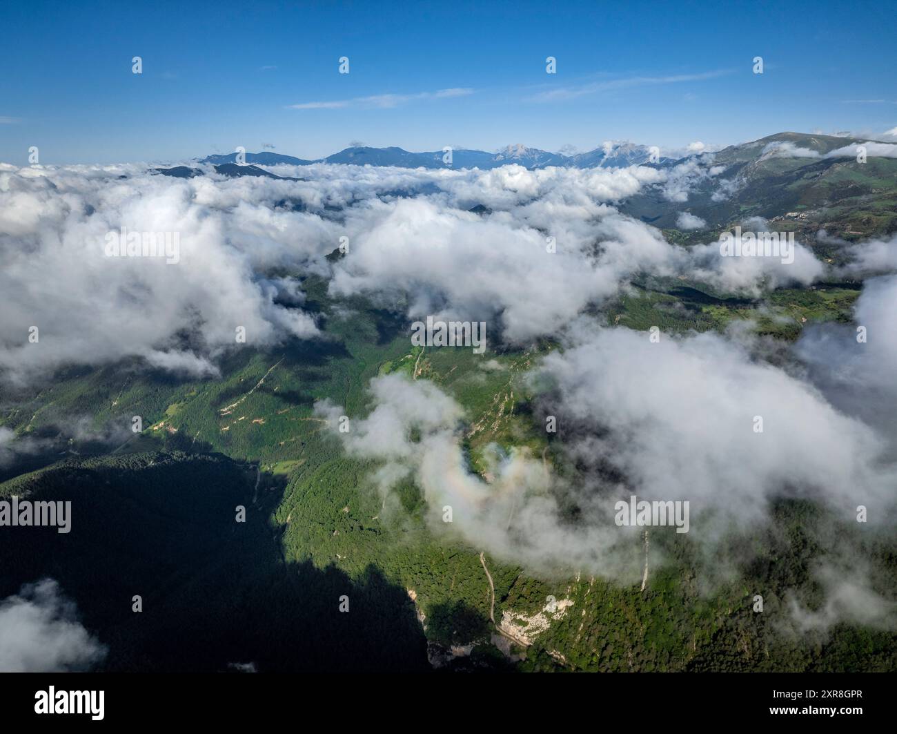 Blick aus der Vogelperspektive auf die Montgrony-Bergkette und das Gombrèn-Tal mit Nebel an einem Frühlingsmorgen. Im Hintergrund der Gipfel von Berguedà und Pedraforca Stockfoto