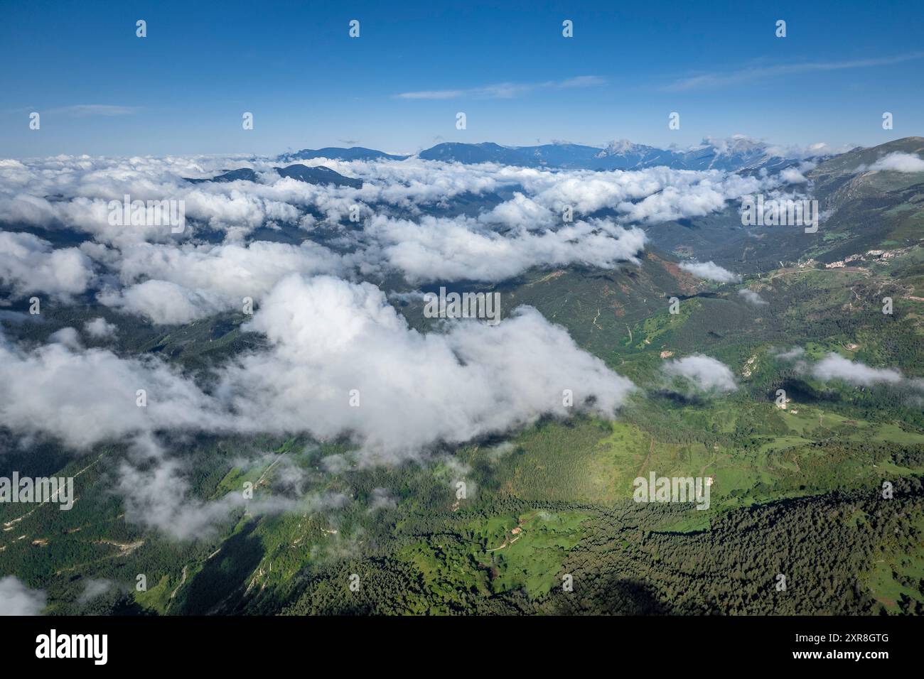 Blick aus der Vogelperspektive auf die Montgrony-Bergkette und das Gombrèn-Tal mit Nebel an einem Frühlingsmorgen. Im Hintergrund der Gipfel von Berguedà und Pedraforca Stockfoto