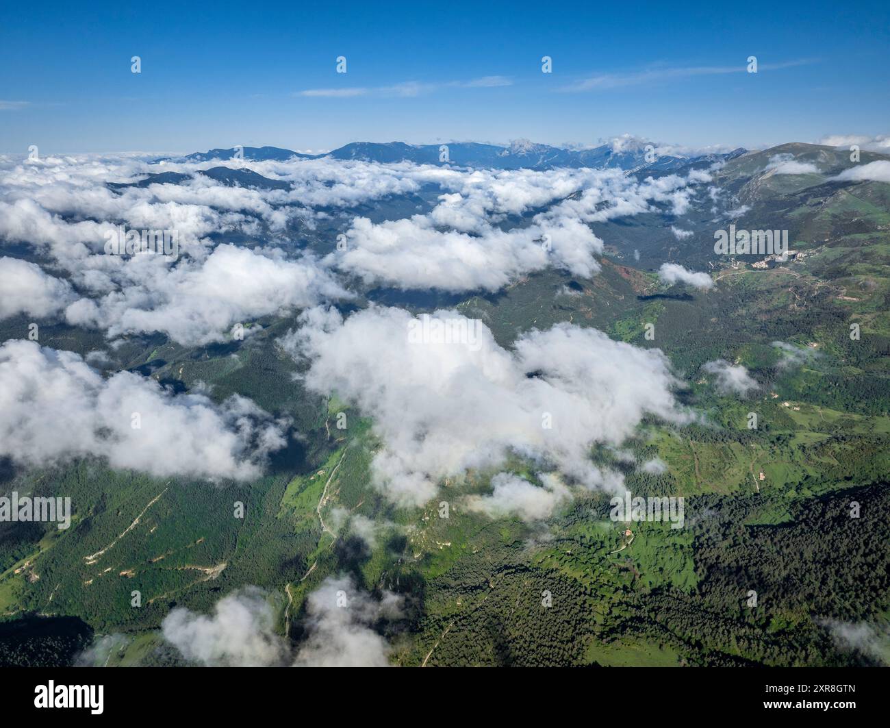 Blick aus der Vogelperspektive auf die Montgrony-Bergkette und das Gombrèn-Tal mit Nebel an einem Frühlingsmorgen. Im Hintergrund der Gipfel von Berguedà und Pedraforca Stockfoto