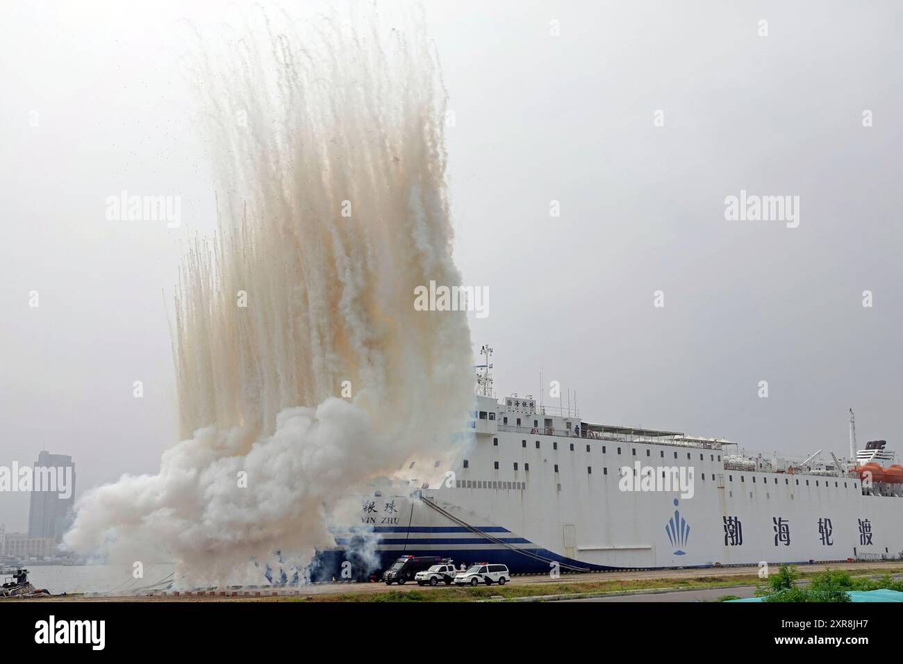 YANTAI, CHINA - 9. AUGUST 2024 - Ein nationales Team zur Mobilisierung der Verteidigung tarnt den Schiffsrumpf mit Rauchschirmen während eines umfassenden DE Stockfoto