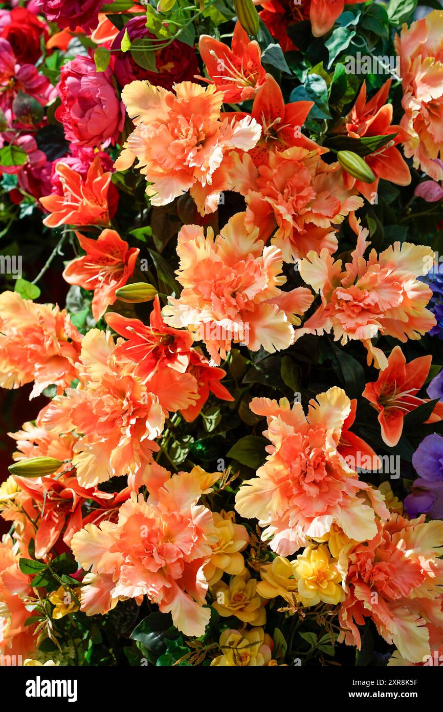 Buntes Sortiment an Kunstblumen bei Sonnenschein. Vollbildaufnahme. Keine Personen. Stockfoto