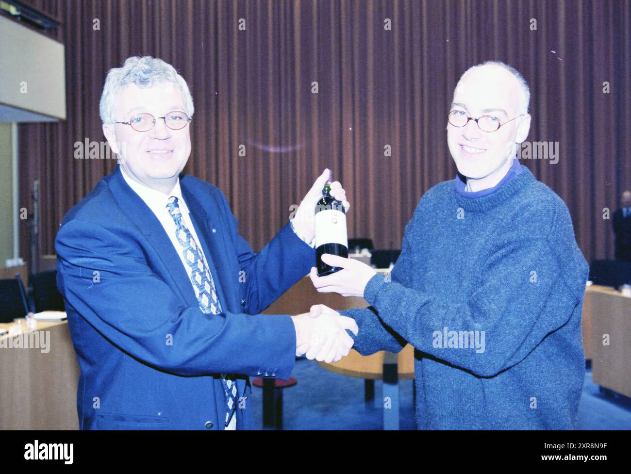 Wilfred erhält eine Flasche Wein vom VVD, 25.03.1998, Whizgle Dutch News: Historical Images Tailored for the Future. Erkunden Sie die Vergangenheit der Niederlande mit modernen Perspektiven durch Bilder von niederländischen Agenturen. Verbinden der Ereignisse von gestern mit den Erkenntnissen von morgen. Begeben Sie sich auf eine zeitlose Reise mit Geschichten, die unsere Zukunft prägen. Stockfoto