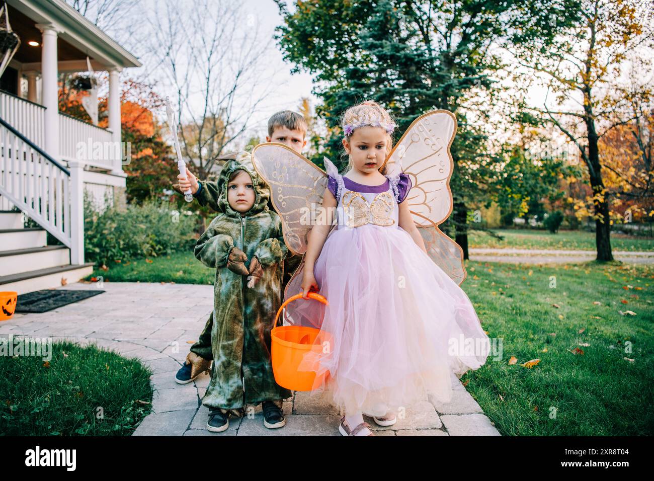 Kinder in Feen- und Dinosaurierkostümen im Freien Stockfoto