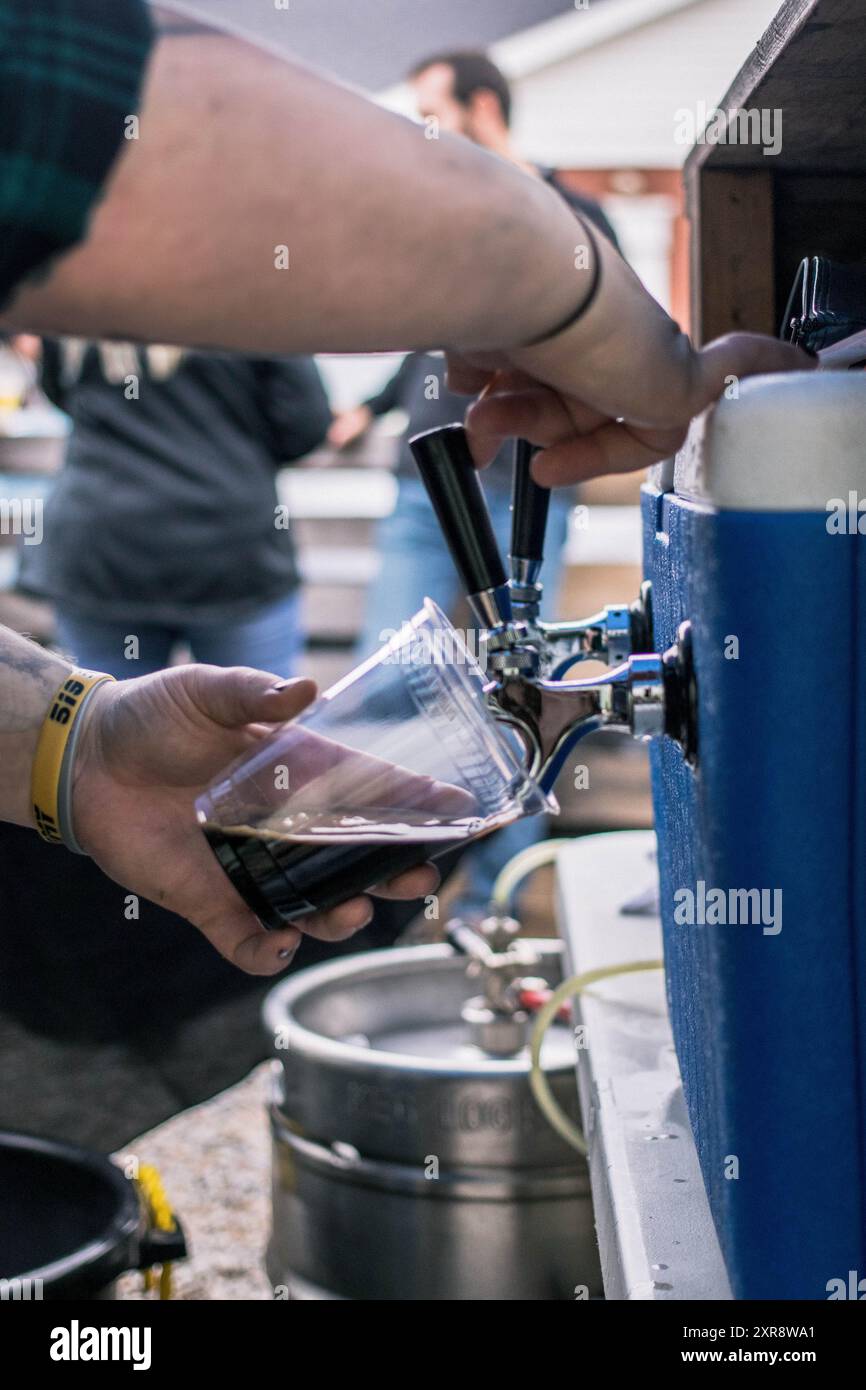 Ein dunkles Bier in einem Biergarten ausgießen Stockfoto