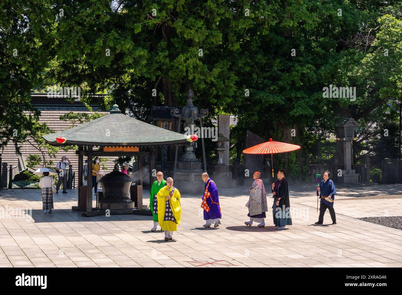 Narita, Japan - 23. Juli 2024: Priester gehen an einem sonnigen Sommertag in Richtung der Haupthalle des Naritasan Shinsho-JI-Tempels in der Nähe von Tokio Stockfoto