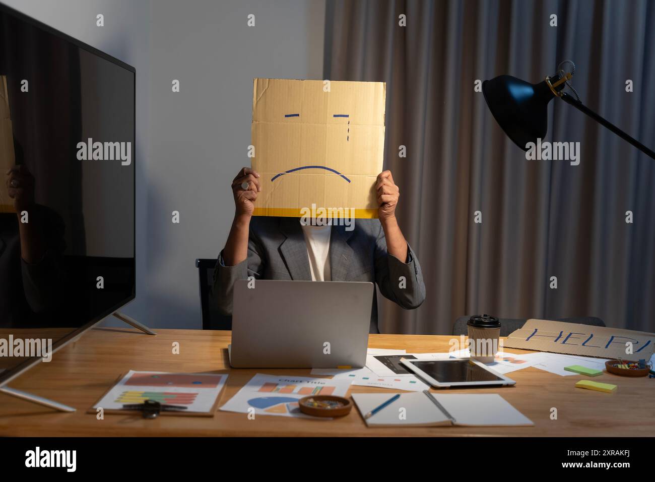 Porträt eines Geschäftsmannes, der sein Gesicht mit einer Papiermaske bedeckt, mit traurigem Gesicht darauf gezeichnet, eine schlechte negative, mürrische Depression anonymose Person. Stockfoto
