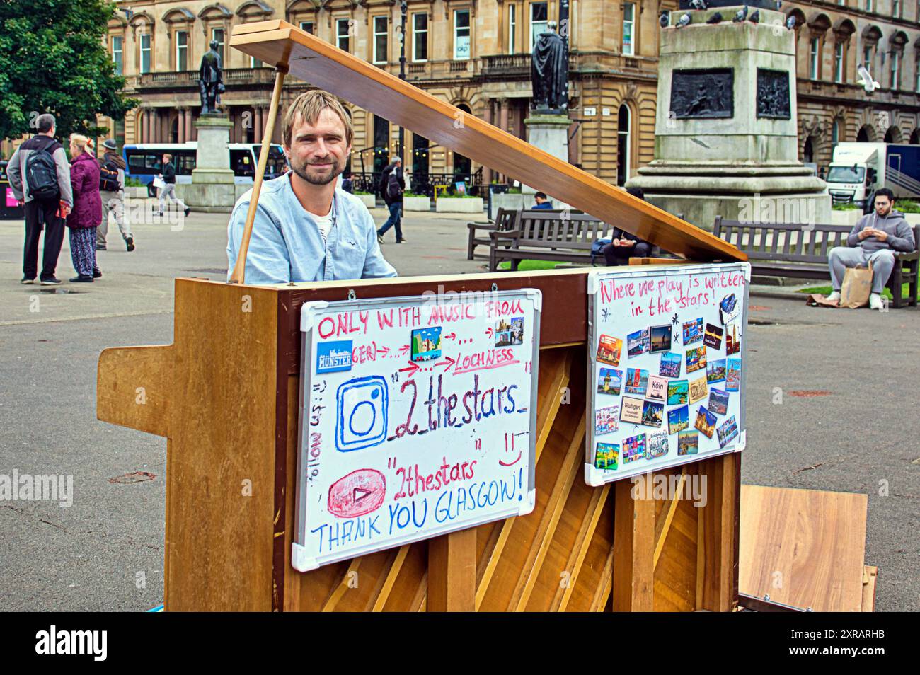 Glasgow, Schottland, Großbritannien. August 2024. Jungs, die Klavier durch europa ziehen, spielen im Zentrum der Stadt auf dem george Square mit Brettern, die seine Reise und seine Geschichte zeigen. Auf TOUR 24: #Busfahrt nach #nessie auf dem Weg zum Loch Eness m.youtube.com/@2thestars, nächster Halt edinburgh Festival. . Credit Gerard Ferry /Alamy Live News Stockfoto