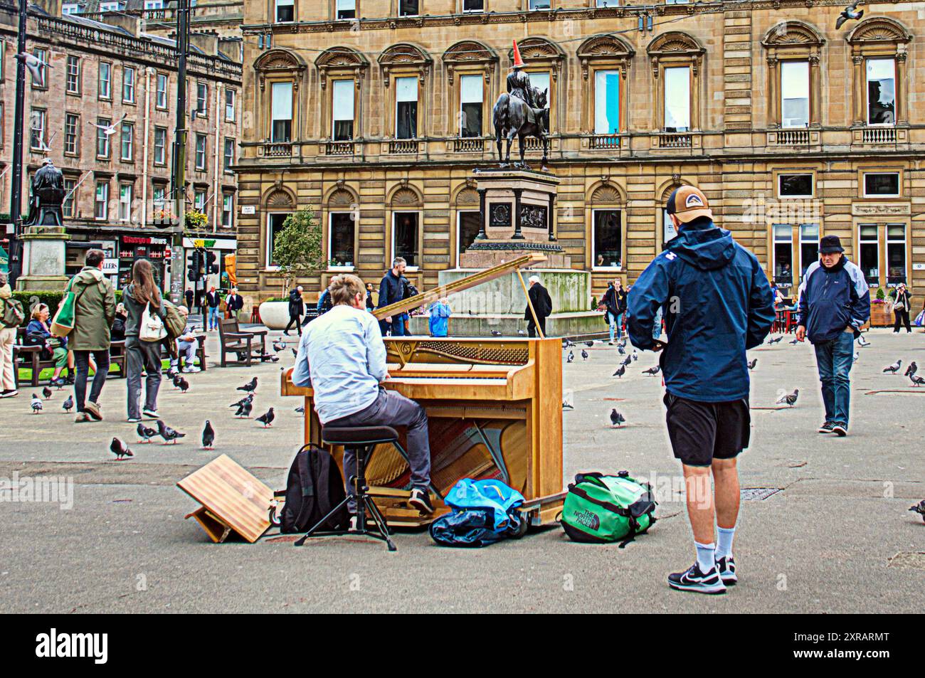 Glasgow, Schottland, Großbritannien. August 2024. Jungs, die Klavier durch europa ziehen, spielen im Zentrum der Stadt auf dem george Square mit Brettern, die seine Reise und seine Geschichte zeigen. Auf TOUR 24: #Busfahrt nach #nessie auf dem Weg zum Loch Eness m.youtube.com/@2thestars, nächster Halt edinburgh Festival. . Credit Gerard Ferry /Alamy Live News Stockfoto