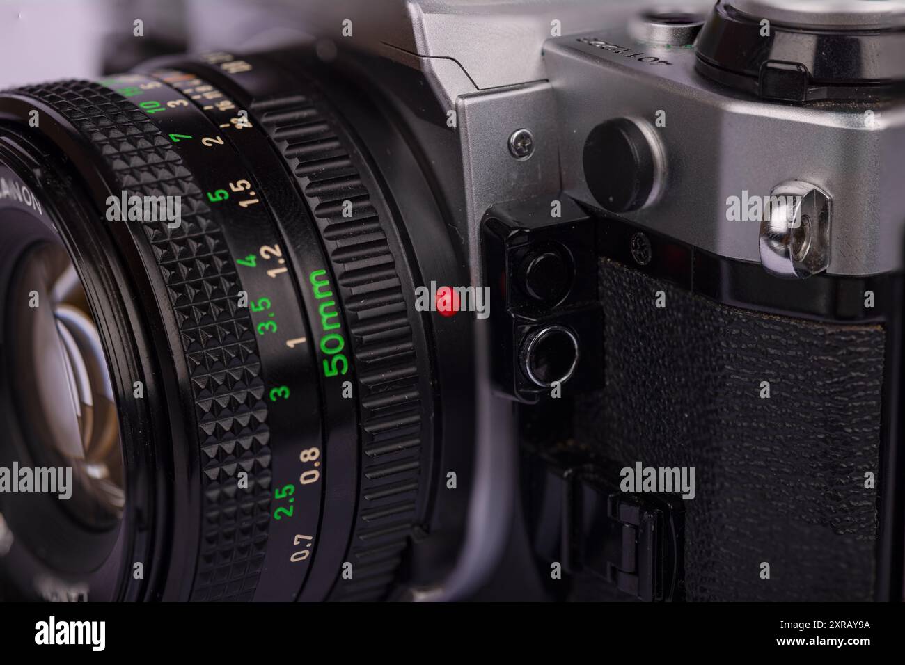 Detailansicht einer antiken Kamera mit Fokus auf den Objektivverriegelungsmechanismus vor weißem Hintergrund. Hebt die klassische Fototechnologie hervor. Stockfoto