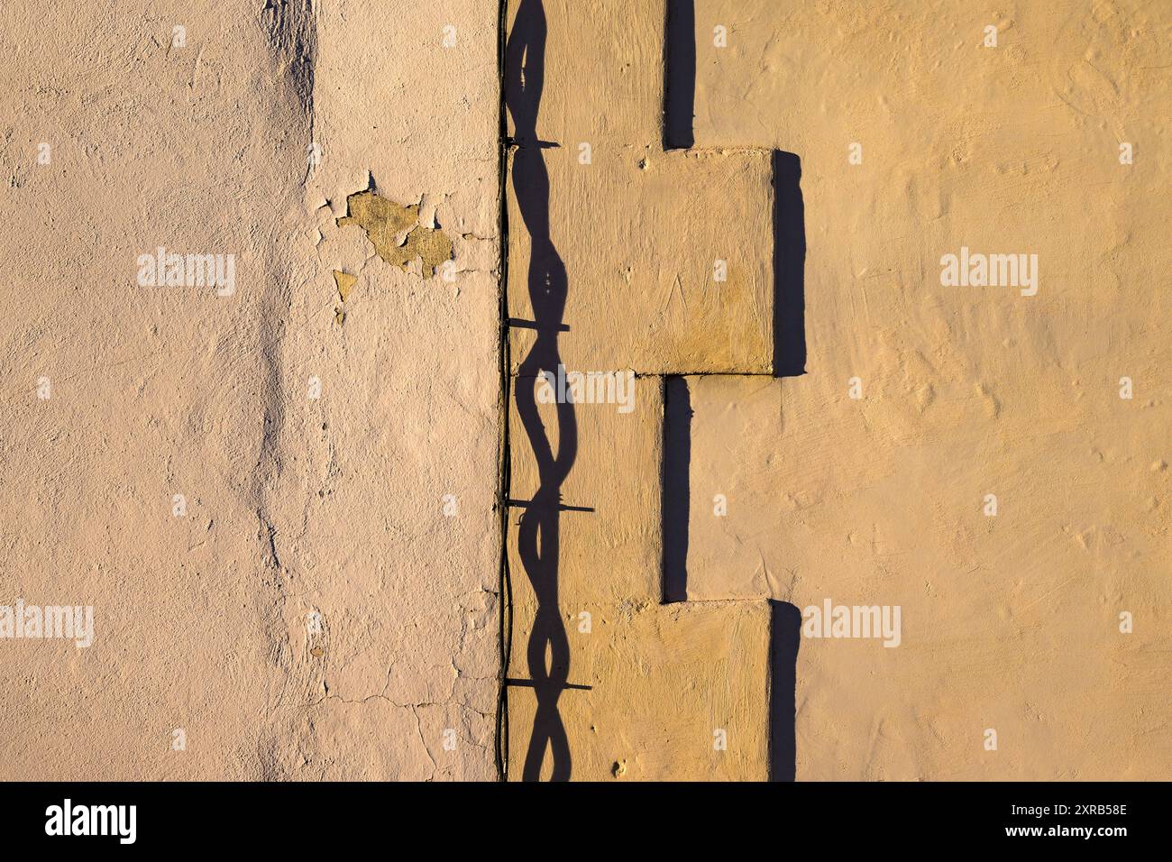 Abstrakte Schatten an einer Wand während Sonnenaufgang, Kabel und Kanten Arles France Stockfoto