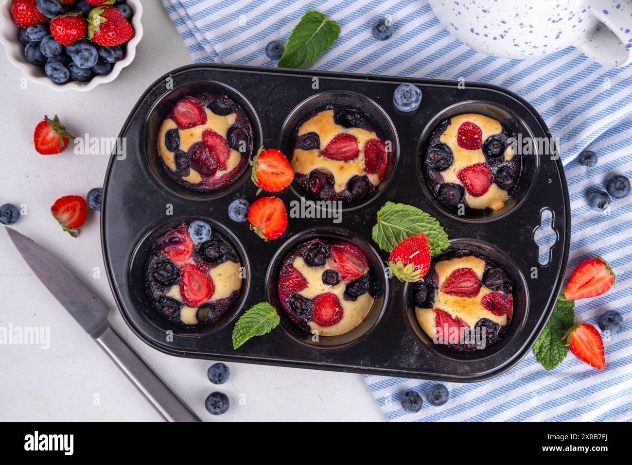 Portionierte gemischte Beerenblätter Pan Baked Pancakes, einfaches Rezept in Muffindosen. Mit frischer Heidelbeere und Erdbeere, Kopierraum Stockfoto
