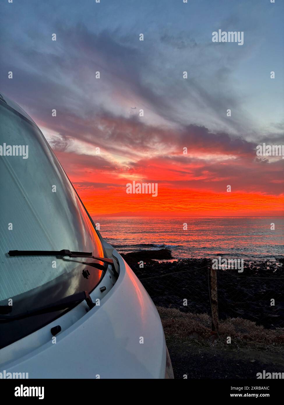 Fantastischer Sonnenuntergang von außen gesehen, ein Wohnmobil parkt an der Küste. Freiheit und Reise alternativer Lebensstil. Mieten eines Wohnmobils für Sommerurlaub Sonnenaufgang auf dem Meer Stockfoto