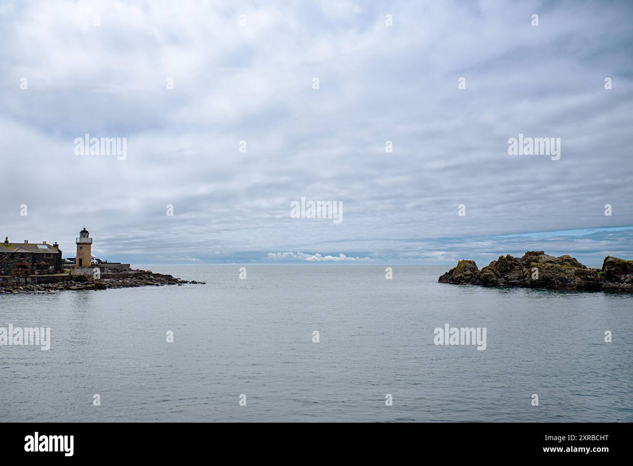 Landschaftsfotografie des alten Hafens und Leuchtturms, der Felsküste, der Bucht, des Meeres, des Dorfes; Schottland; Vereinigtes Königreich; Portpatrick; Landschaft; Gelassenheit; Landschaft Stockfoto