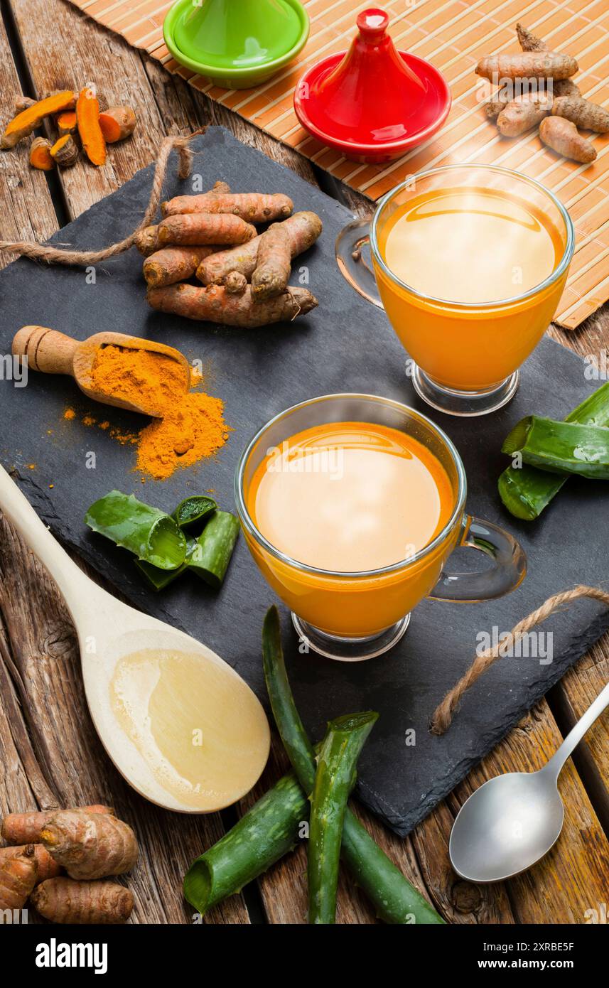 Heißes Getränk mit Aloe Vera und Kurkuma. Tassen aus Glas auf einem Schiefer Tablett. Stockfoto