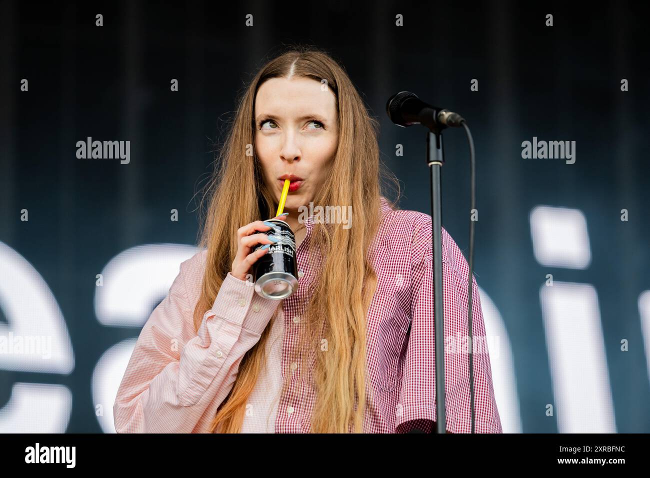 Florence Shaw von der Band Dry Cleaning trinkt ein Getränk auf der Bühne bei Bearded Theory, Catton Hall, Mai 2024 Stockfoto