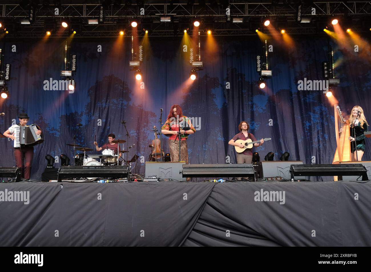 Williamscot, Großbritannien. August 2024. l-r Amy Thatcher, Joe Truswell, Kathryn Tickell, Kieran Szifris, Josie Duncan und The Darkening treten live auf der Bühne der Cropredy Convention auf. Kathryn Tickell ist Komponist, Interpretin und Pädagogin. Benannt nach dem alten northumbrischen Wort für Twilight, besteht The Darkening aus vier Mitgliedern aus Nordost-England, Amy Thatcher Akkordeon, Joe Truswell Drums, Kathryn Tickell Vocals und North Pipes, Kieran Szifris Gitarre und Mandoline, Josie Duncan Harfe und Gesang. Quelle: SOPA Images Limited/Alamy Live News Stockfoto