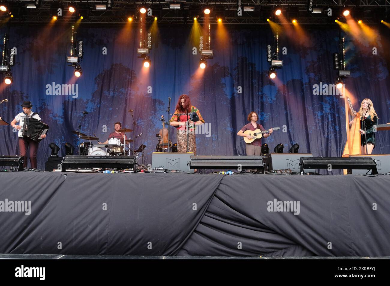 Williamscot, Großbritannien. August 2024. l-r Amy Thatcher, Joe Truswell, Kathryn Tickell, Kieran Szifris, Josie Duncan und The Darkening treten live auf der Bühne der Cropredy Convention auf. Kathryn Tickell ist Komponist, Interpretin und Pädagogin. Benannt nach dem alten northumbrischen Wort für Twilight, besteht The Darkening aus vier Mitgliedern aus Nordost-England, Amy Thatcher Akkordeon, Joe Truswell Drums, Kathryn Tickell Vocals und North Pipes, Kieran Szifris Gitarre und Mandoline, Josie Duncan Harfe und Gesang. Quelle: SOPA Images Limited/Alamy Live News Stockfoto