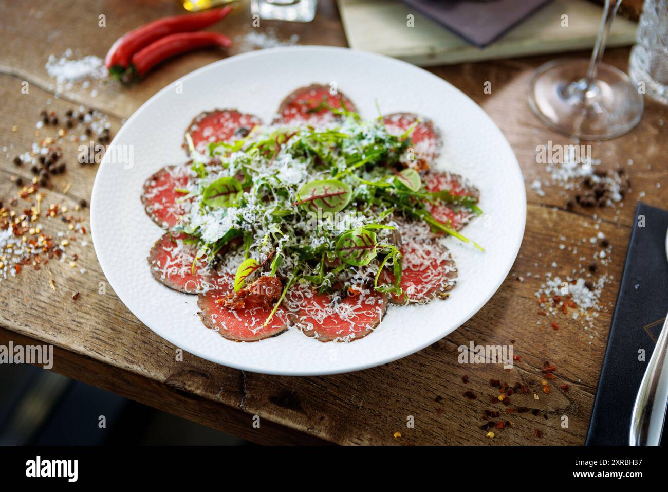 Rindfleisch-Carpaccio. Borettane-Zwiebeln, sonnengetrocknete Tomaten, Trüffeldressing, Rucola-Salat, Parmesankäse. Traditionelle italienische Antipasti-Snacks serviert Stockfoto