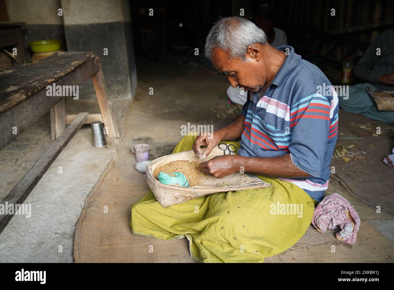 Kalkutta, Indien, 30. Dezember 2023. BIDI-Arbeiter in Uluberien ertragen harte Bedingungen. In Uluberia, Bezirk Howrah, Westbengalen, arbeiten die Arbeiter von Bidi (handgerollte Zigaretten) unter beklagenswerten Bedingungen. Sie arbeiten in engen, schlecht belüfteten Räumen, die mit Tabakstaub gefüllt sind, was schwerwiegende gesundheitliche Risiken birgt. Trotz langer Arbeitszeiten erhalten sie magere Löhne, viele leiden unter Atemwegserkrankungen. Die Bidi-Industrie, die für die lokale Wirtschaft von entscheidender Bedeutung ist, wurde für die Ausbeutung ihrer Arbeitskräfte kritisiert, doch hat sich wenig geändert. Dringende Reformen sind erforderlich, um eine bessere Bezahlung und eine sicherere Arbeitsumgebung zu gewährleisten Stockfoto