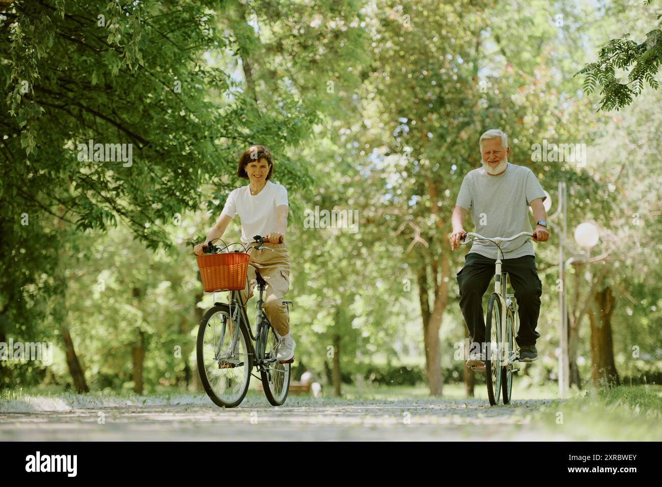 Sportliche Seniorenfrau und Ehemann fahren Fahrrad, um gesund im Ruhestand zu bleiben Stockfoto