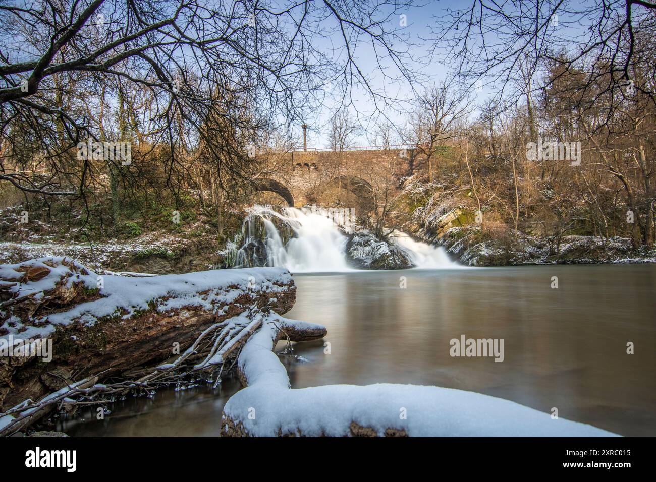 Wunderschöne Landschaft im Winter mit Eis und Schnee. Wasserfall der Eltz bei Schloss Pyrmont, landgasthof Pyrmonter Mühle direkt an einem See, historische Brücke in Rheinland-Pfalz Stockfoto