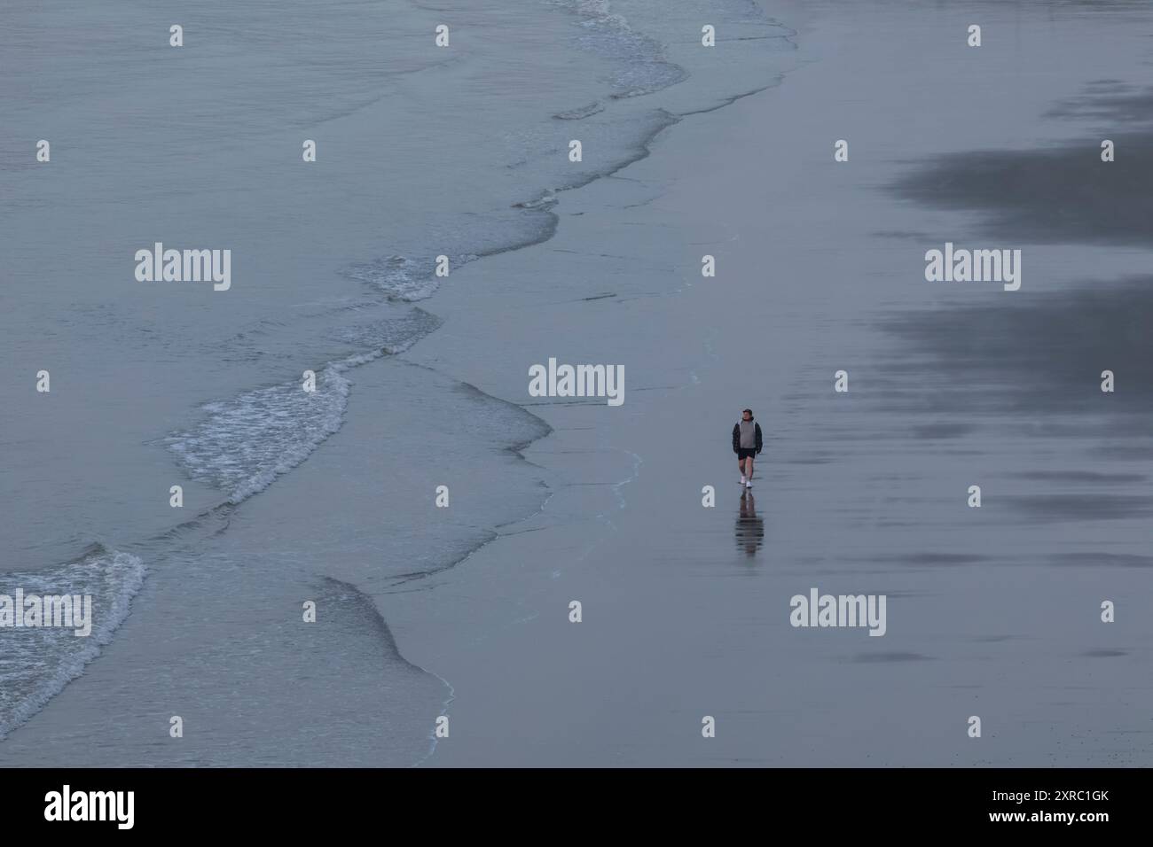 England, Kent, Folkestone, Sunny Sands Beach, Single man Walking on Empty Beach Stockfoto