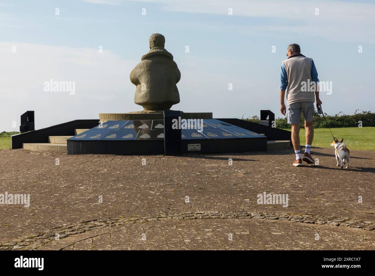 England, Kent, Folkestone, Capel-le-ferne, das Battle of Britain Memorial, Besucher mit Hund, der an der Battle of Britain Statue vorbeigeht Stockfoto