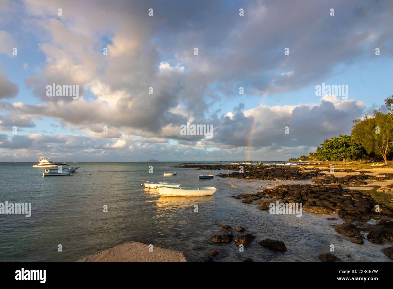 Landschaft mit Blick über einen kleinen Hafen mit Fischerbooten bei Sonnenuntergang am Kap Malheureux, Mauritius Stockfoto