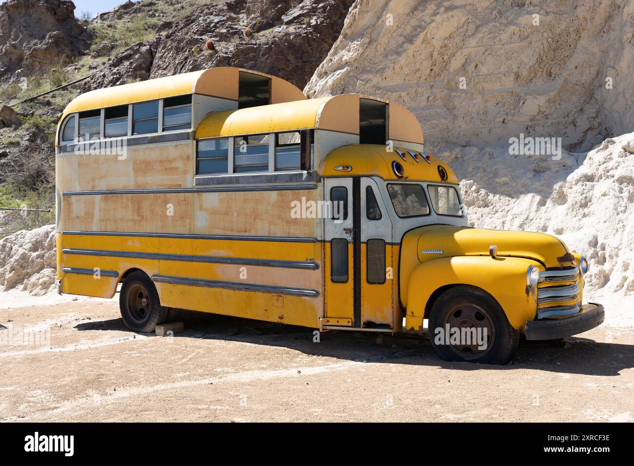 Nelson, NV/USA - 6. April 2024: Verwitterter Old School Bus sitzt verlassen auf einem Wüstengelände Stockfoto