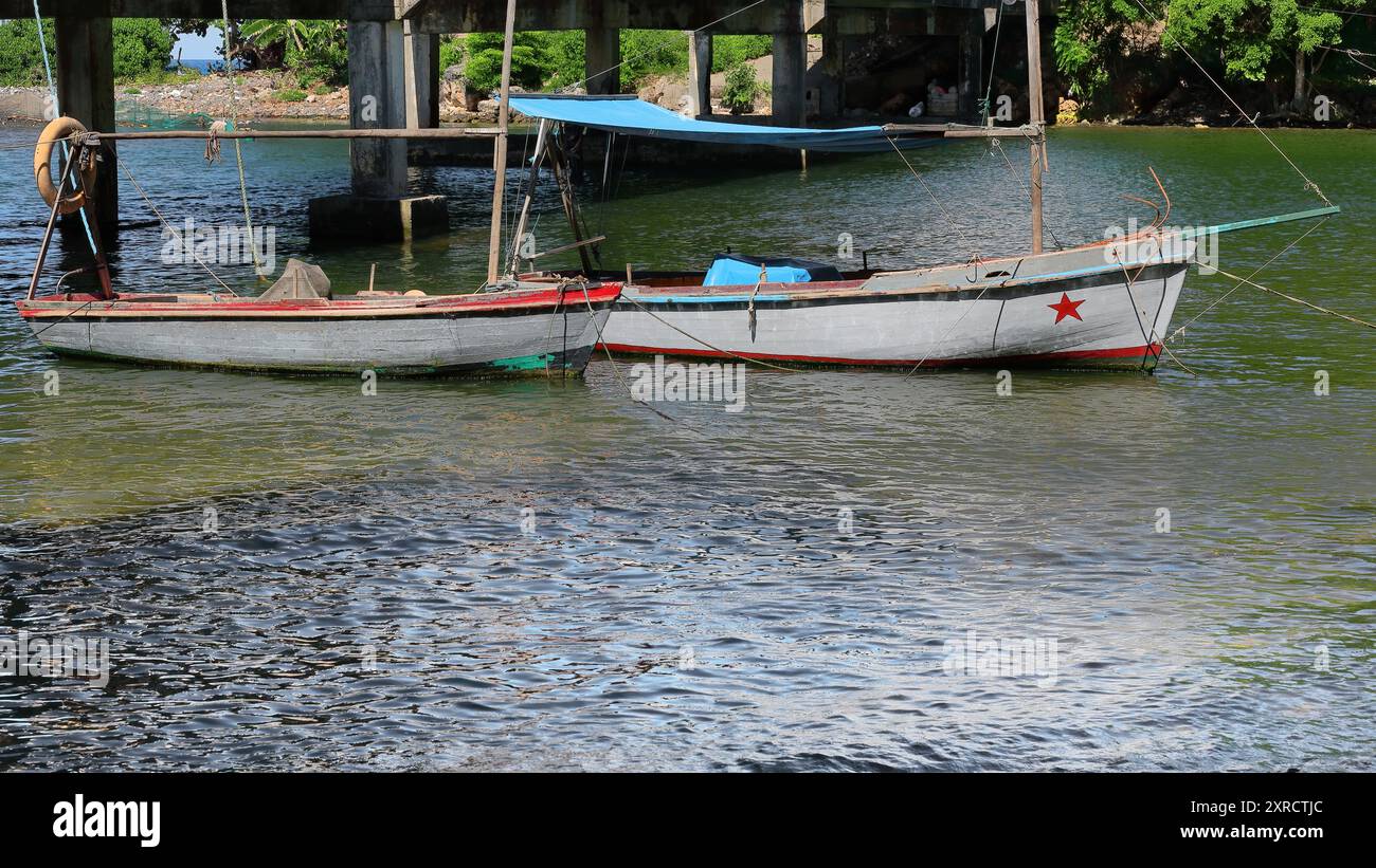 590 Touristenboote, die an der Mündung des Rio Yumuri ankern, warten darauf, dass Besucher sie entlang des Flusses, der sich über ca. 4 km bis Baracoa-Kuba erstreckt, transportieren. Stockfoto