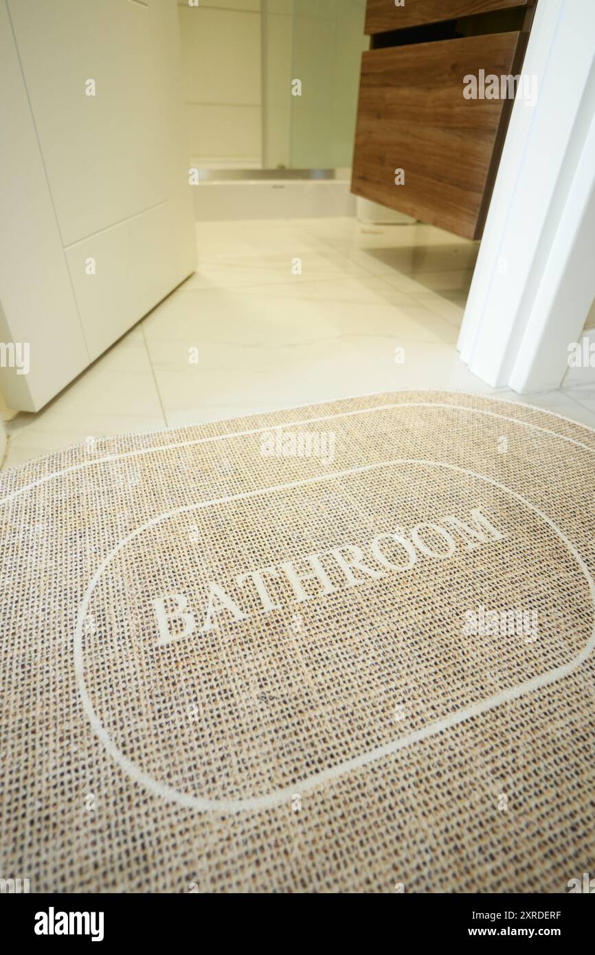 Eine Badezimmermatte auf einem sauberen Fliesenboden schafft eine einladende und gemütliche Atmosphäre im Zimmer Stockfoto