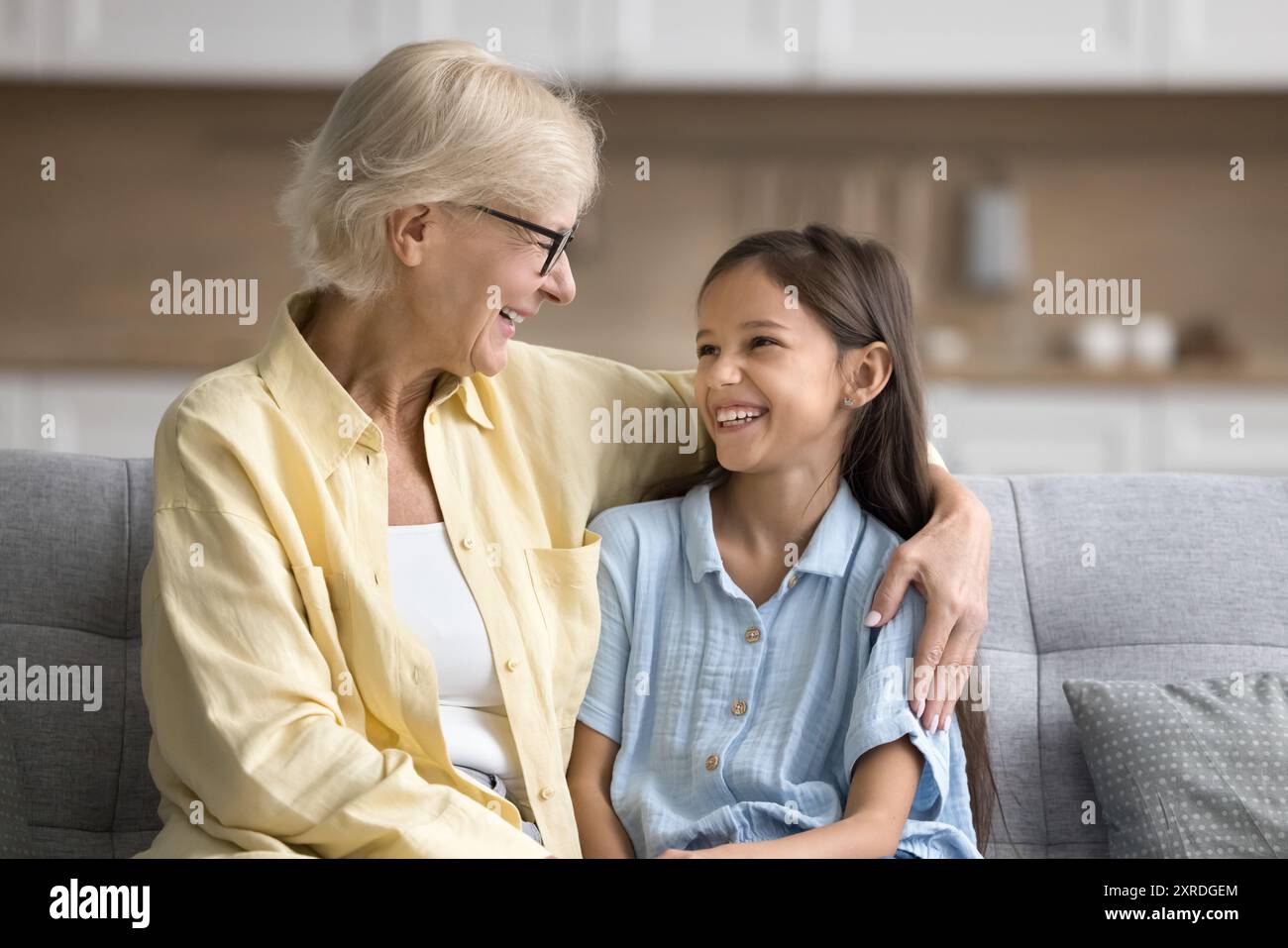 Glückliche, liebevolle Großmutter umarmt glückliche, schöne Enkelin Stockfoto