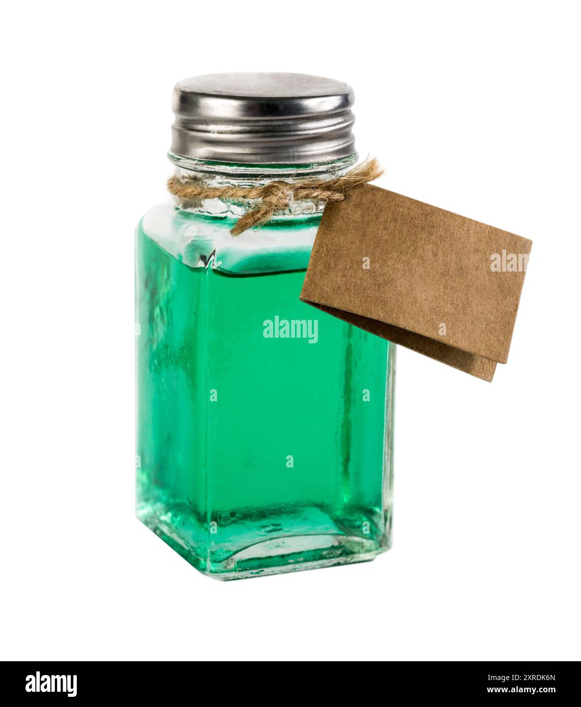 Glasbehälter im Vintage-Stil mit grüner Flüssigkeit. Der Behälter verfügt über ein leeres braunes Etikett, das mit einem Seil befestigt ist. Stockfoto